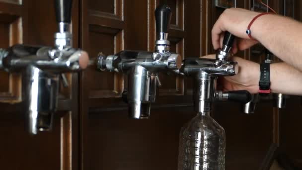 Mann gießt Bier in eine Plastikflasche. Bierabfüllanlage. Barmann serviert in der Taverne. - Filmmaterial, Video