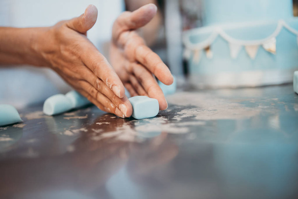 Professional confectioner working making and decorating delicious sweets. Close up shot. - 写真・画像