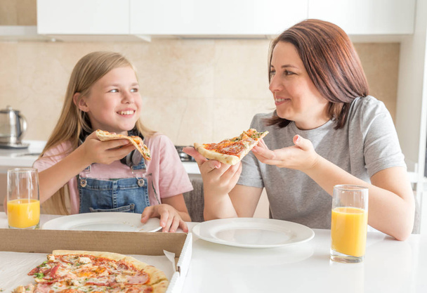 家族の概念、おいしいピザを食べる母と娘 - 写真・画像