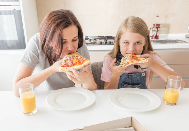 家族の概念、おいしいピザを食べる母と娘 - 写真・画像