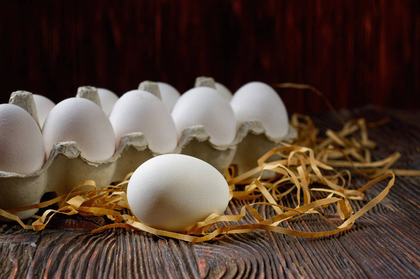 Fresh white eggs on the village table. Low key. - Fotó, kép