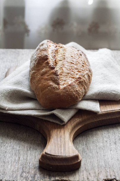 Bochenek pełnoziarniste chleb z drewna na stole kuchennym - Zdjęcie, obraz
