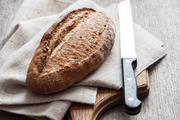 Brood van volkoren brood houten plank op keuken tafel - Foto, afbeelding