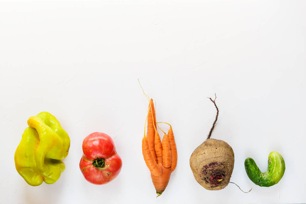 Ugly vegetables on a white background. Ugly food concept, flat lay, copy space. - Foto, imagen