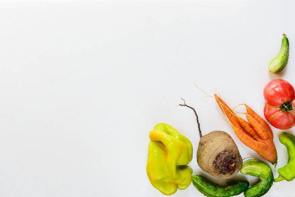 Уродливые овощи на белом фоне. Уродливая концепция питания, плоский уголок, копировальное пространство
. - Фото, изображение