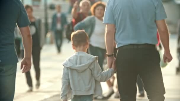 Dav lidí, kteří chodí po ulicích-muž, který drží syna za ruku - Záběry, video