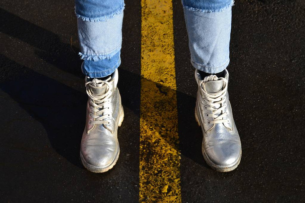  Women's silver boots and blue jeans. - 写真・画像