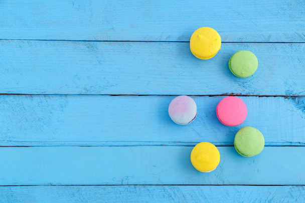 barevné makaróny nebo macaroony sušenky na modrém dřevěném ročníku ba - Fotografie, Obrázek