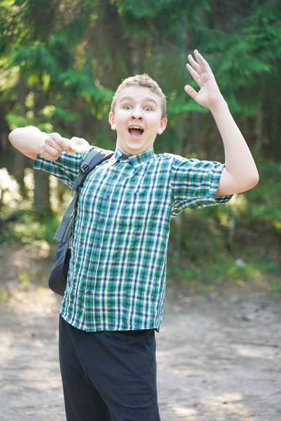 夏の日に森の中でキノコを持つティーンエイジャーの少年 - 写真・画像