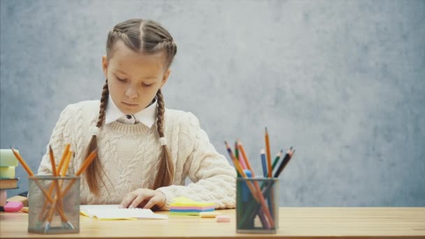 かわいい女の子は緑の鉛筆を選択し、それがシャープにされているかどうかを確認しています. - 映像、動画