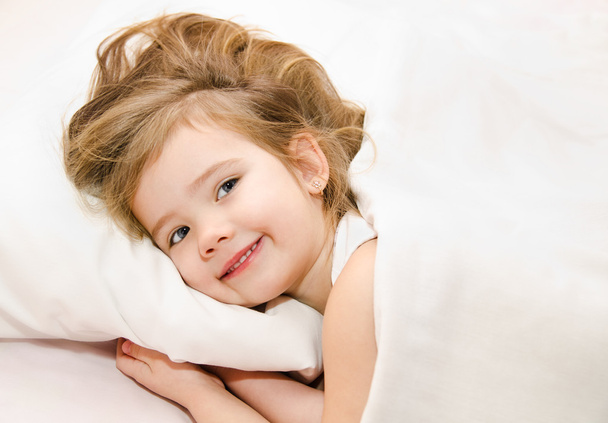 Adorable little girl awaked up in her bed - Foto, imagen