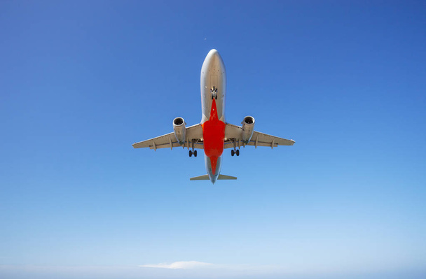 Utasszállító repülőgép leszállás a tiszta, kék ég és a felhők háttér - Fotó, kép
