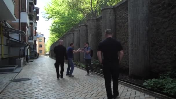 Grupa uzbrojonych muggers atakujących mężczyznę na pasie miejskim - Materiał filmowy, wideo