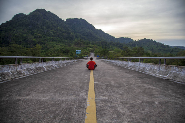 El concepto de infinito y soledad - un hombre se sienta en el camino
  - Foto, imagen