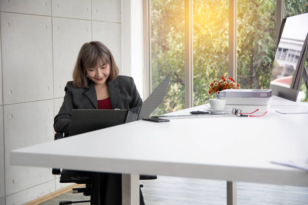 Businesswoman working in front of computer thinking of project v - Foto, Bild