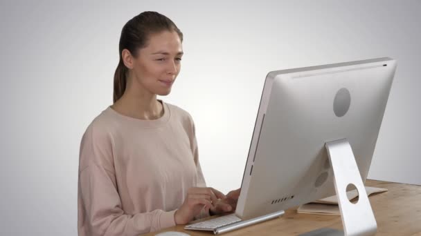 コンピュータを使用して、グラデーションの背景に微笑むアイデアを持っているブロンドの女性. - 映像、動画