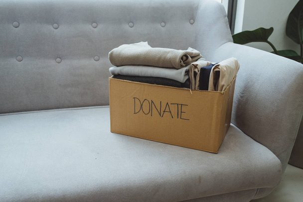 kleding in doos voor concept donatie en hergebruik recycling - Foto, afbeelding