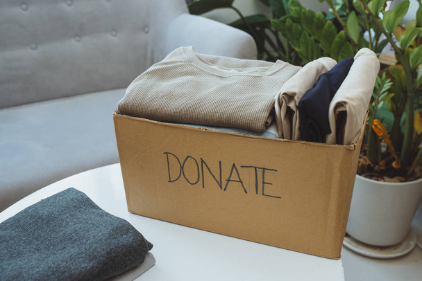 Donation box and casual clothes in livingroom - Foto, Imagen