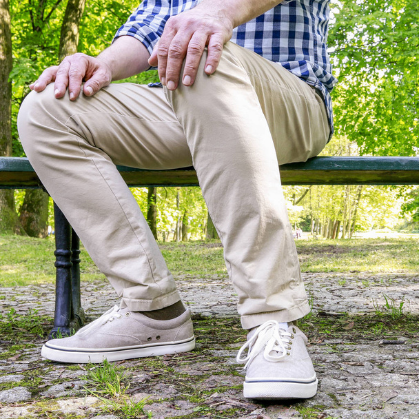 Man sitting on the bench in beautiful summer park.   - Foto, Imagen