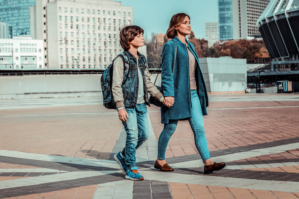 Happy female person walking with her son - 写真・画像