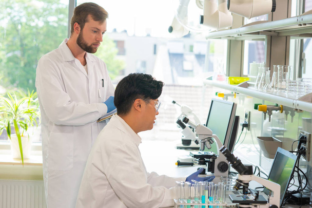 研究室で働く科学者や学生。医師はインターンに分析研究を教える。研究室のツール:顕微鏡、試験管、機器。生物学、化学、細菌学、ウイルス学、 DNA - 写真・画像