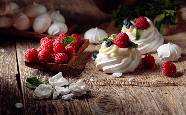 Десерт Павлова с малиной, черникой и мятой на старом
  - Фото, изображение