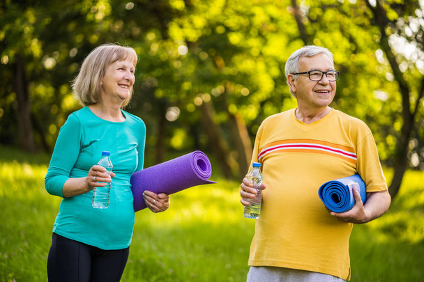 Ευτυχισμένο ζευγάρι ηλικιωμένων είναι έτοιμο για άσκηση στο πάρκο.  - Φωτογραφία, εικόνα