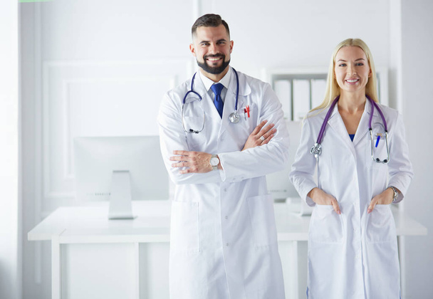 A medical team of doctors, man and woman,in a consultancy room - Фото, изображение