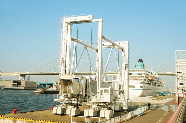 Przejście pasażera jachtu teleskopowe (pokład mostu) do odbioru i wysadzenia pasażerów jachtu w porcie Osaka na jasnoniebieskim tle nieba, jest głównym portem w Japonii, znajduje się w Osace w Zatoce Osaka - Zdjęcie, obraz