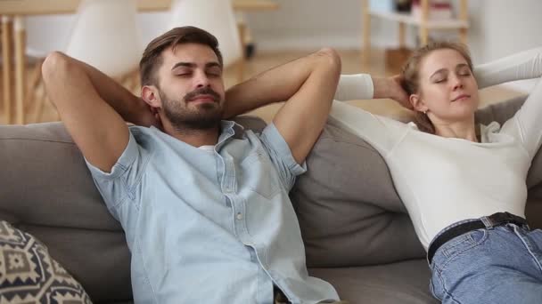 Couple putting hands behind head resting on couch feels good - Filmati, video