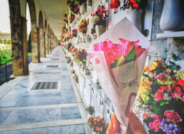Φέρνουμε λουλούδια στους αγαπημένους μας στο νεκροταφείο κατά τη διάρκεια της μέρας των νεκρών - Φωτογραφία, εικόνα