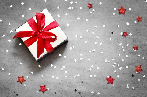 Caja de regalo con cinta roja sobre fondo gris con estrella
. - Foto, imagen