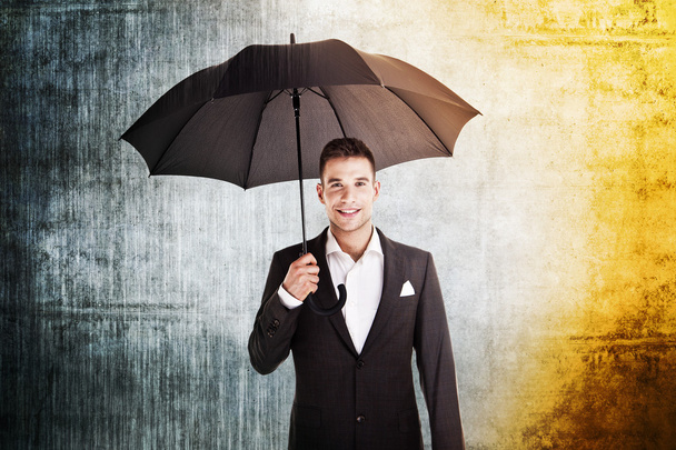 бізнесмен під дощем і сонцем тримає парасольку
 - Фото, зображення
