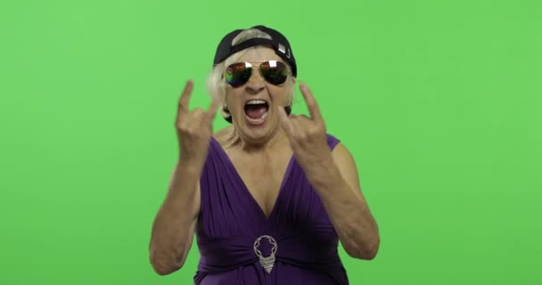 Oudere vrouw in zonnebrillen schreeuteert met een glimlach en toont tong. Chroma Key - Video