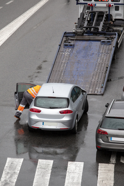 Szene eines kaputten Autos auf einer Straße der Stadt bereit, auf die Plattform des Flachbett-Abschleppwagens zu laden - Foto, Bild