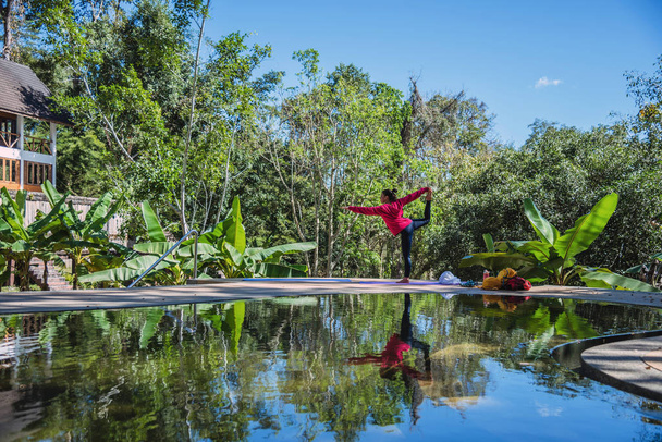 Ασιάτισσα ταξιδεύει στη φύση. Ταξίδι χαλαρώστε. Σταντ γυμναστικής Yoga στην πισίνα. - Φωτογραφία, εικόνα