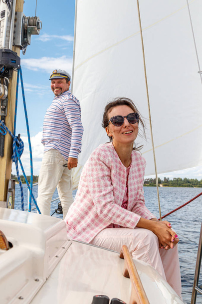 marinero en una gorra con una chica en un barco a vela contra el
 - Foto, imagen
