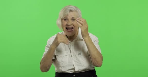 An elderly woman shout and waving with hands. Old grandmother smiles. Chroma key - 映像、動画