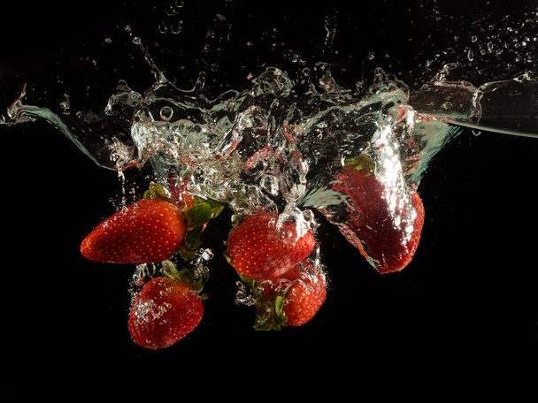 Strawberries splashing into water - Фото, зображення