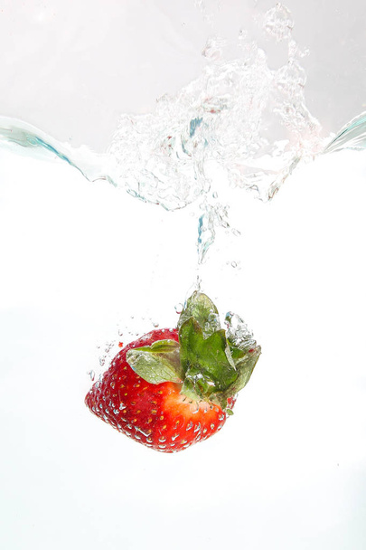 Strawberri splashing into water - 写真・画像