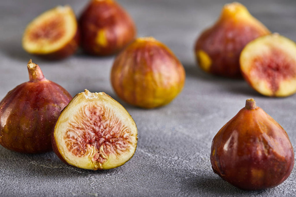Fresh figs whole and cut into pieces on a gray background, the concept of a healthy - Foto, imagen