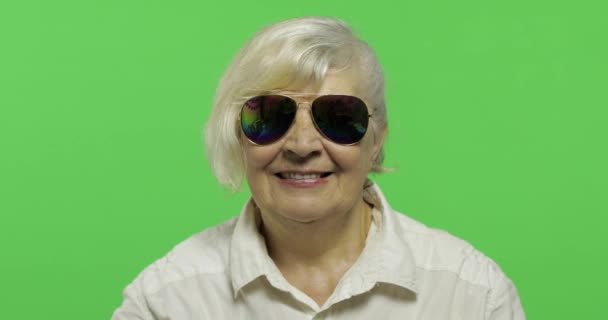 Een oudere vrouw in zonnebrillen tonen duim omhoog en glimlacht. Chroma Key - Video