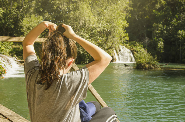 Woman tying back her hair on the nature  - Photo, Image