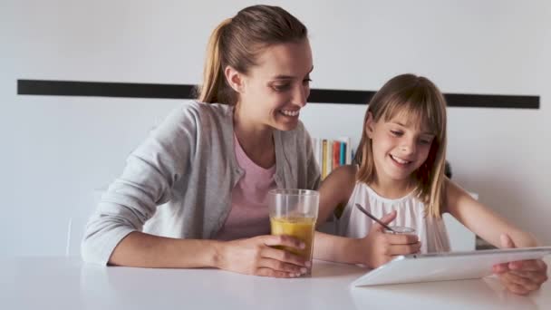 Krásná mladá matka a její dcera používající digitální tablet doma. - Záběry, video