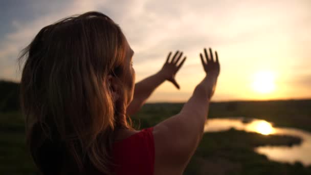 Εμπνευσμένη γυναίκα που κάνει μια χειρονομία καρδιάς στη μικρή λίμνη του ηλιοβασιλέματος στο ηλιοβασίλεμα σε αργή κίνηση - Πλάνα, βίντεο
