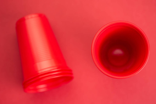 Gafas de plástico rojo sobre fondo rojo, vista superior
 - Foto, imagen