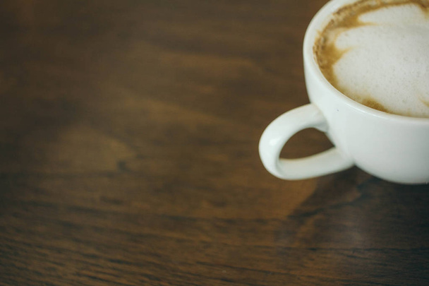 Кавова чашка і кавові зерна на дерев'яному столі в кафе
 - Фото, зображення
