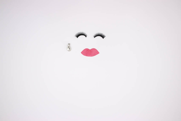 Woman's jewelry and eye lashes on white background  - Valokuva, kuva