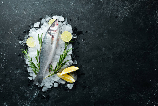 Sea fish seabass. Seafood on a black stone background. Top view. Free copy space. - Foto, Imagen