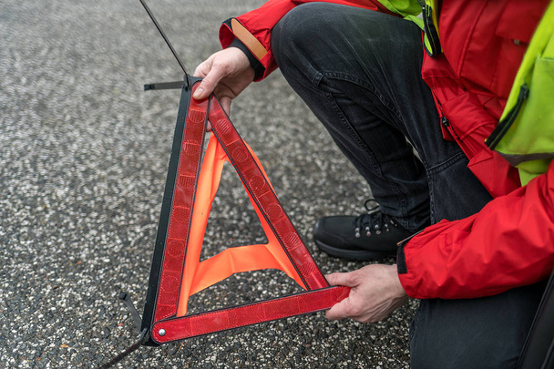 Osoba staví na ulici výstražný trojúhelník - Fotografie, Obrázek
